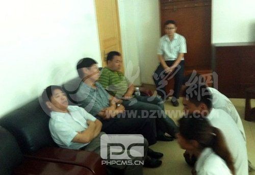 在寿光市人民医院接待室,3名死者家属向院方人员下跪,院方人员表情漠然。(大众网记者摄)