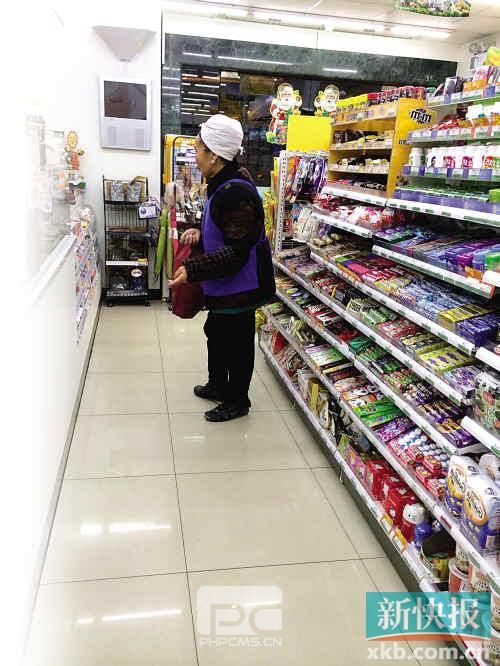 ■一个大妈在超市的收银台前守候讨钱。