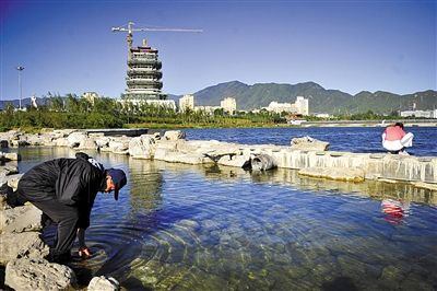 2012年，一市民在北京门头沟永定河门城湖畔驻足，远处是永定楼。新京报记者 李飞 摄