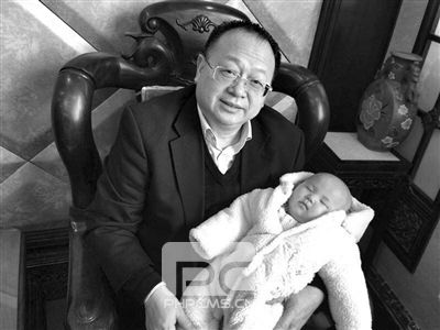 罗志元（左）抱着一个女婴。微博截图